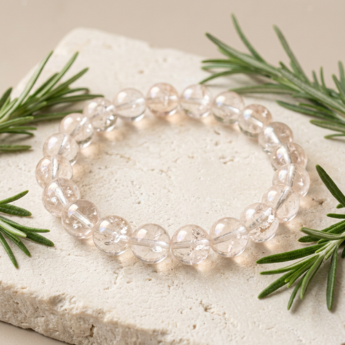 Clear quartz bracelet with rosemary on pale stone