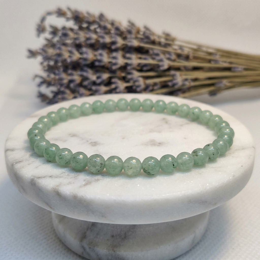 Green Aventurine bracelet on marble pedestal with lavender