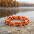 Sardonyx bracelets beside a lake reflecting autumn trees