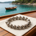 Balance bracelet with wooden boat on turquoise water